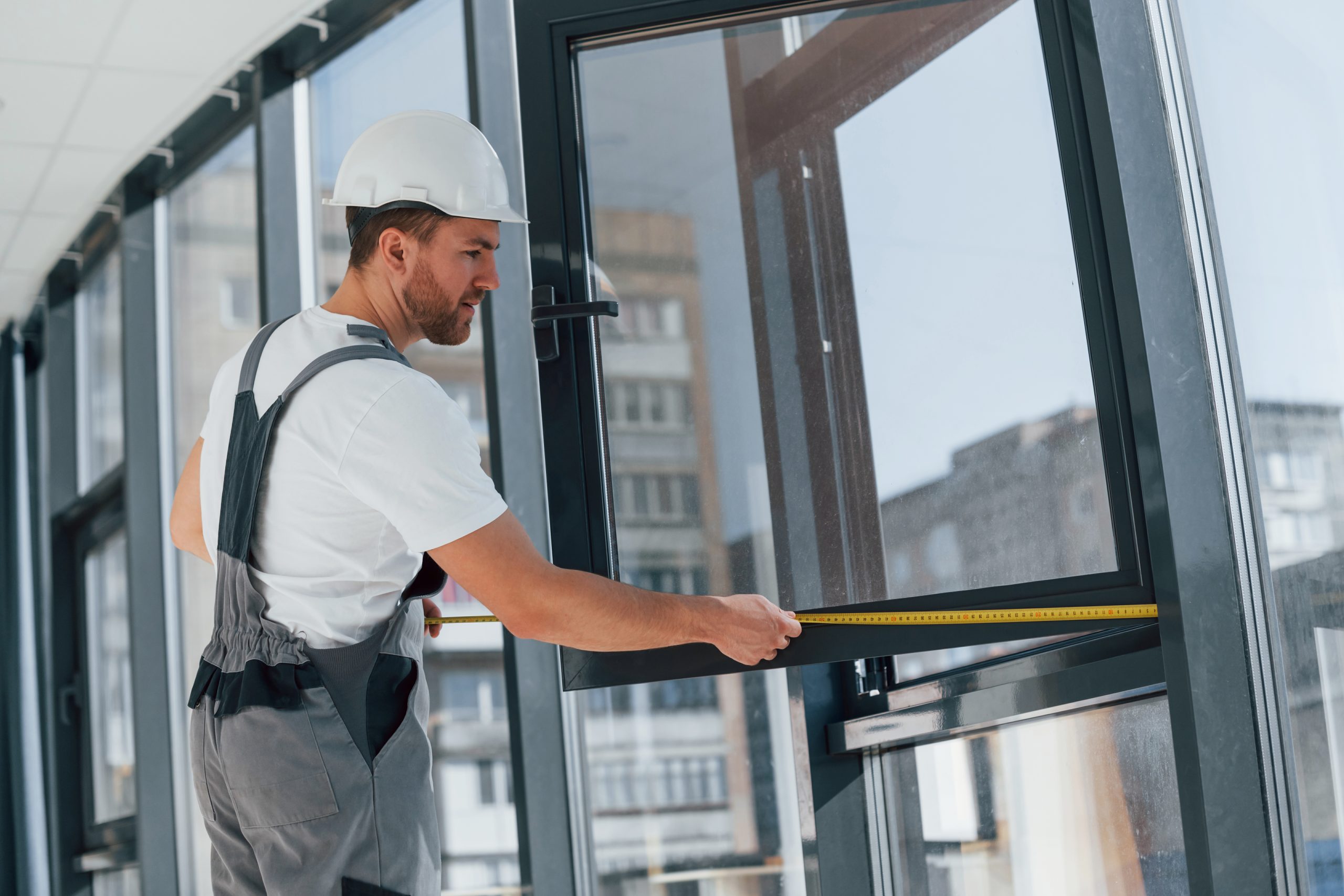 Holding window. Repairman is working indoors in the modern room.